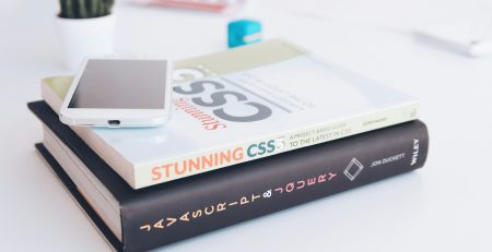 white smartphone on two softbound books